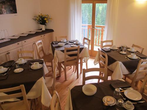 a dining room with tables and chairs with black tablecloths at Il Cardo Trentino in Bedollo
