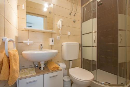 a bathroom with a toilet and a sink and a shower at Vito in Novi Vinodolski