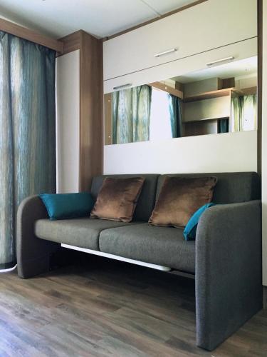 a living room with a couch and a mirror at Hótel Eyvindará in Egilsstadir