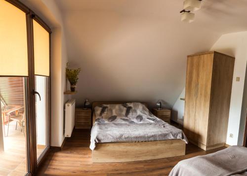 1 dormitorio con 1 cama y armario de madera en Przystan Kurpiowska en Turośl