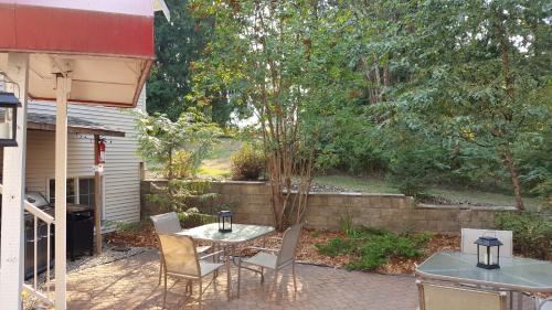 a patio with a table and chairs in a backyard at The Inn at the Ninth Hole Bed & Breakfast in Salmon Arm