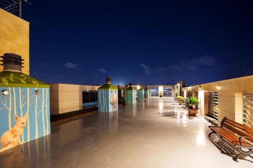 a building with a walkway with benches on it at Ramada by Wyndham Jeju City Hall in Jeju
