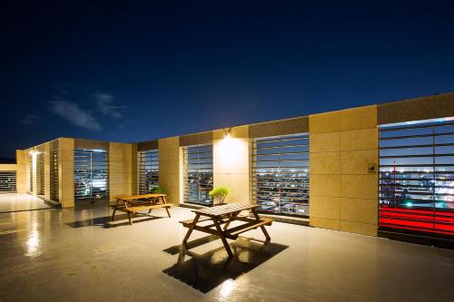 a building with two picnic tables on the roof at night at Ramada by Wyndham Jeju City Hall in Jeju