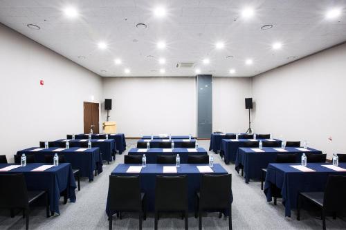 a room with blue tables and chairs in it at Ramada by Wyndham Jeju City Hall in Jeju