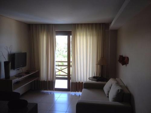 a living room with a couch and a sliding glass door at Residence Kariri Beach Cumbuco in Cumbuco