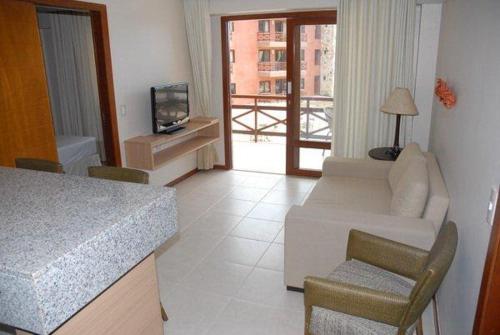 a living room with a white couch and a television at Residence Kariri Beach Cumbuco in Cumbuco