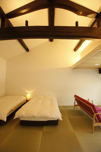 a bedroom with two beds and a chair at Yamagata The Takinami in Nanyo