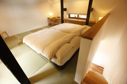 a bedroom with a white bed in a room at Yamagata The Takinami in Nanyo