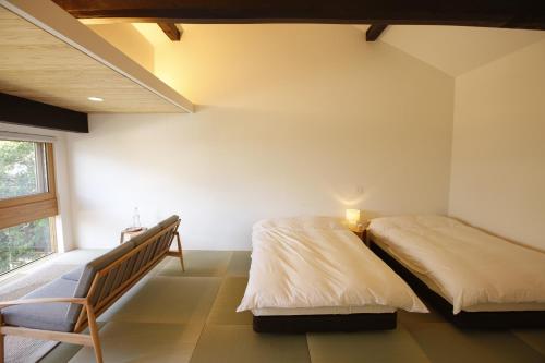 a bedroom with two beds and a window at Yamagata The Takinami in Nanyo