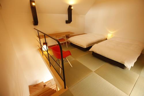 a room with two beds and a table and a chair at Yamagata The Takinami in Nanyo