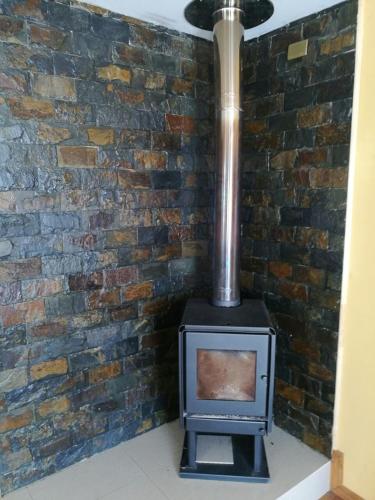 a stove in front of a brick wall at Casa Rukalma Estación in Villarrica