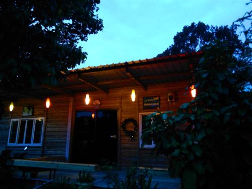 a house with lights on the front of it at Saengcha Farm Resort in Prachin Buri