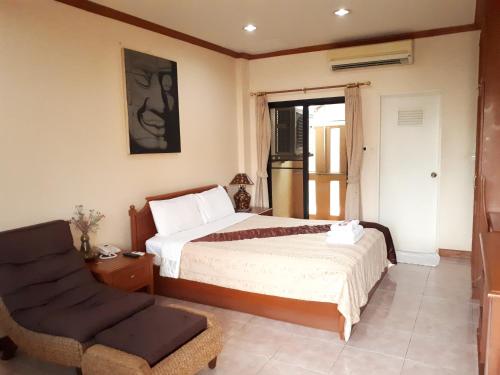 a bedroom with a bed and a chair at Mini Cost Apartment&Guesthouse in Chiang Mai