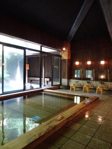 a swimming pool in a building with a large window at Konya in Matsue