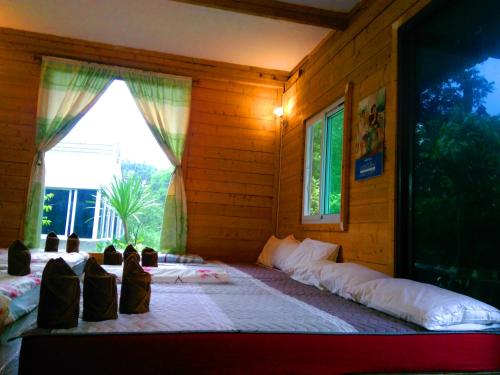 a bedroom with two beds and a window at Saengcha Farm Resort in Prachin Buri