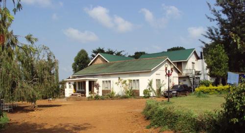 a white house with a green roof at Masaka Backpackers, Tourists Cottage & Campsite in Masaka