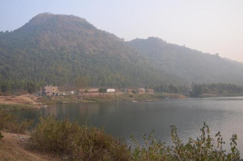 a large body of water with a mountain in the background at Eco Adventure Resorts Khhairabera in Bāghmundi
