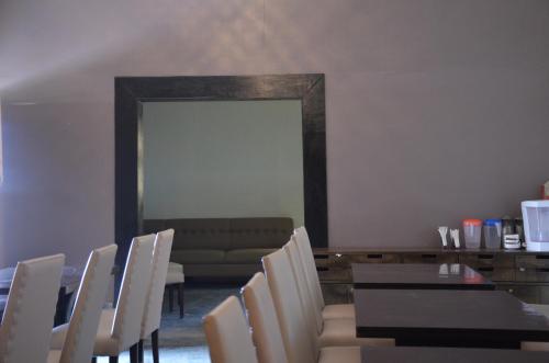 a dining room with a table and chairs and a couch at Eco Adventure Resorts Khhairabera in Bāghmundi
