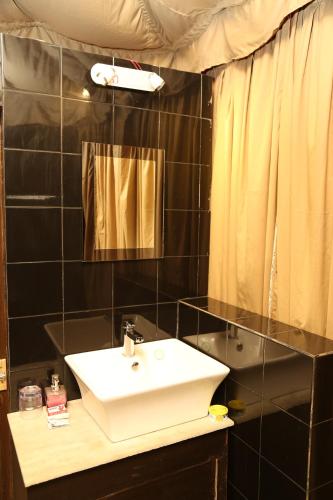 a bathroom with a sink and a mirror at Eco Adventure Resorts Khhairabera in Bāghmundi