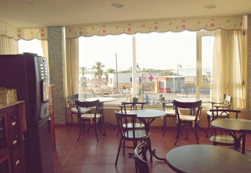 a restaurant with tables and chairs and a large window at Hotel Los Molinos in Lo Pagán