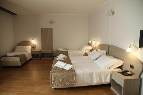 a hotel room with two beds and a table at Monte San Giovanni-Nebrodi Rooms in San Marco dʼAlunzio