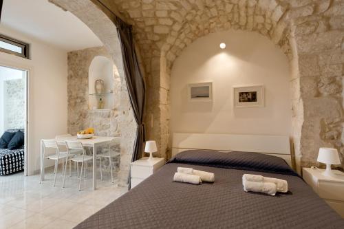 een slaapkamer met een bed en een tafel in een kamer bij Dammuso delle Gioie in Scicli