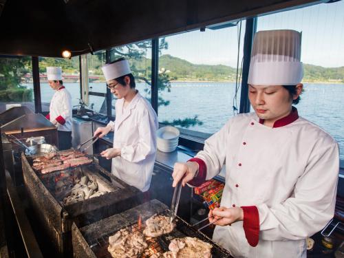 a group of chefs cooking food on a grill at Hotel Green Plaza Hamanako in Hamamatsu
