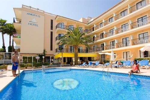 einen Pool in einem Hotel mit Leuten um ihn herum in der Unterkunft Hotel Amoros in Cala Ratjada