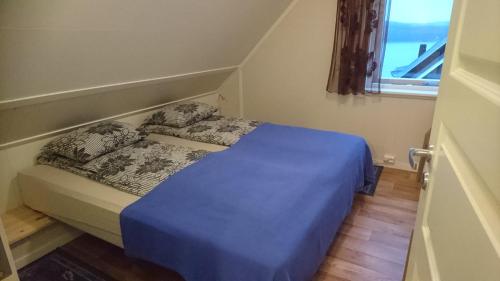 Kirkenes Lodge في كيركينيس: سرير صغير في غرفة مع نافذة