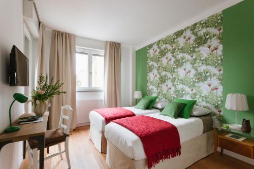 ミラノにあるVivere Milano Isolaのベッド2台と壁画が備わるホテルルームです。