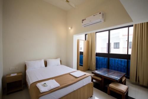 a hotel room with a bed and a window at 2BHK -Balcony & Pool View -Monarch Palms, Cadolim in Candolim