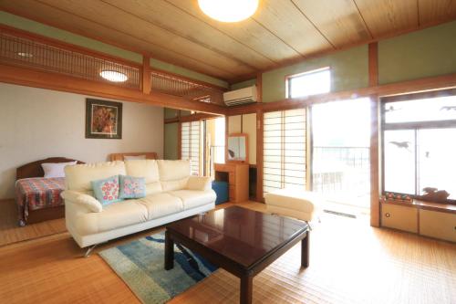 a living room with a couch and a coffee table at Hitoyoshi Morinohall Ladies in - Female Only in Hitoyoshi