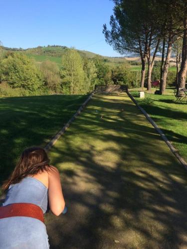 a woman is running down a path in the grass at Agriturismo Piettorri in Casole dʼElsa