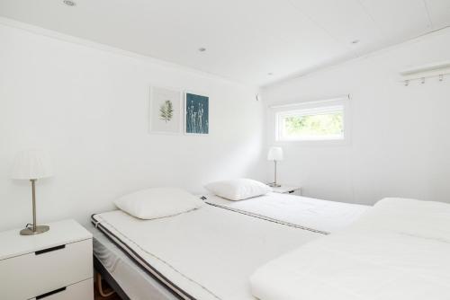 Duas camas num quarto branco com duas janelas em First Camp Edsvik-Grebbestad em Skickeröd