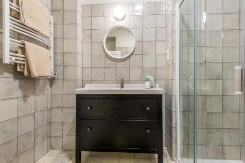een badkamer met een wastafel en een spiegel bij Angel House Vilnius 38 in Vilnius