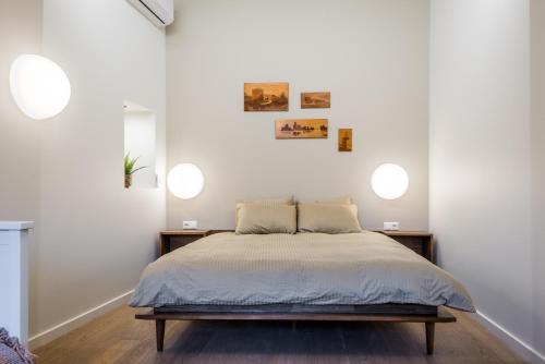a bedroom with a bed and two lights on the wall at Angel House Vilnius 38 in Vilnius