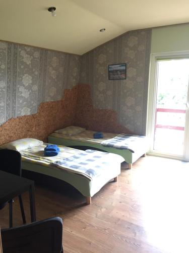 two beds sitting in a room with a window at Nakvynė Rokiškyje in Rokiškis