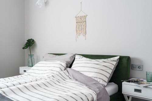 a green couch with white pillows in a living room at Csapô Apartment in Debrecen