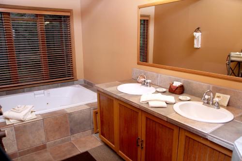 a bathroom with two sinks and a tub at Weasku Inn in Grants Pass