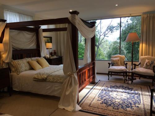 a bedroom with a canopy bed and a large window at Whispering Pines Bed and Breakfast in Collie