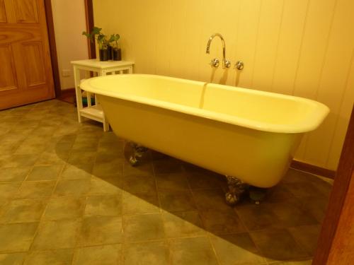 una vasca da bagno con un rubinetto in un bagno di Magnolia Cottage a Cooroy