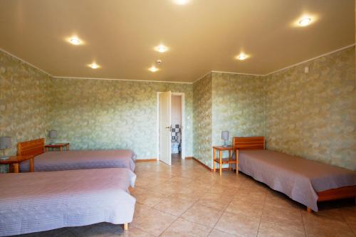 a room with two beds and a table and chairs at Dzeņi in Amatciems