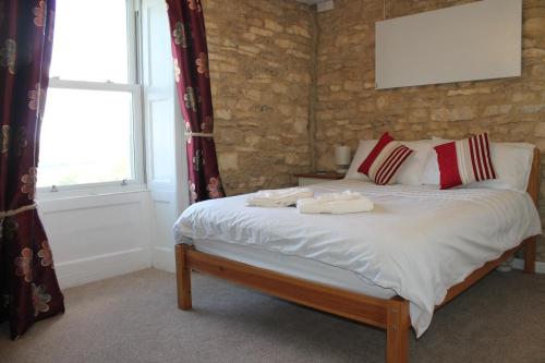 a bedroom with a bed with two towels on it at Snowdrop Cottage in Gloucester