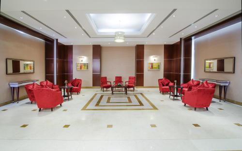 a living room filled with furniture and tables at Concorde Hotel - Fujairah in Fujairah