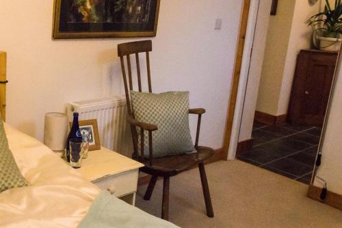 a chair with a pillow sitting in a bedroom at James John Hamilton House and backpacker hostel in Fishguard