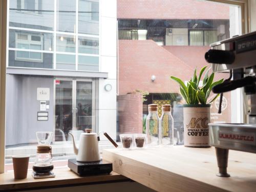 a counter with bottles and glasses on a window at almond hostel & cafe Shibuya in Tokyo
