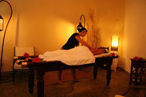 a woman in a room making a bed with a person at Hotel Gallo Nero in SantʼAndrea