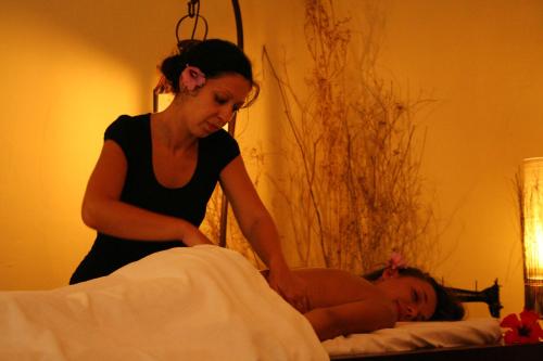a woman is standing over a child laying on a bed at Hotel Gallo Nero in SantʼAndrea