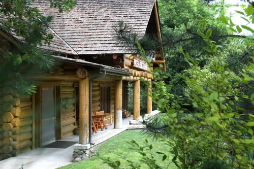 a log cabin with a porch and a table at Weasku Inn in Grants Pass