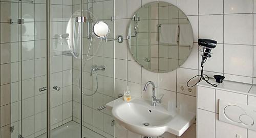 y baño con ducha, lavabo y espejo. en Gästehaus Kloep GmbH, en Hillesheim